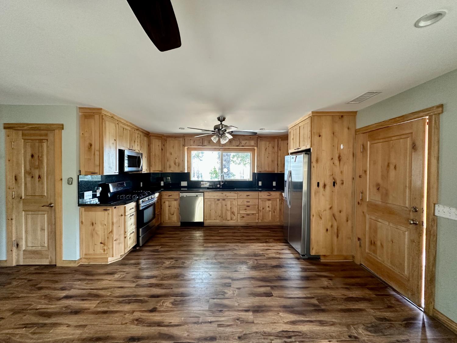38295 Cressman Road Shaver Lake, CA 93664 - Photo 4 of 31 a kitchen with stainless steel appliances kitchen island granite countertop a refrigerator and a stove top oven