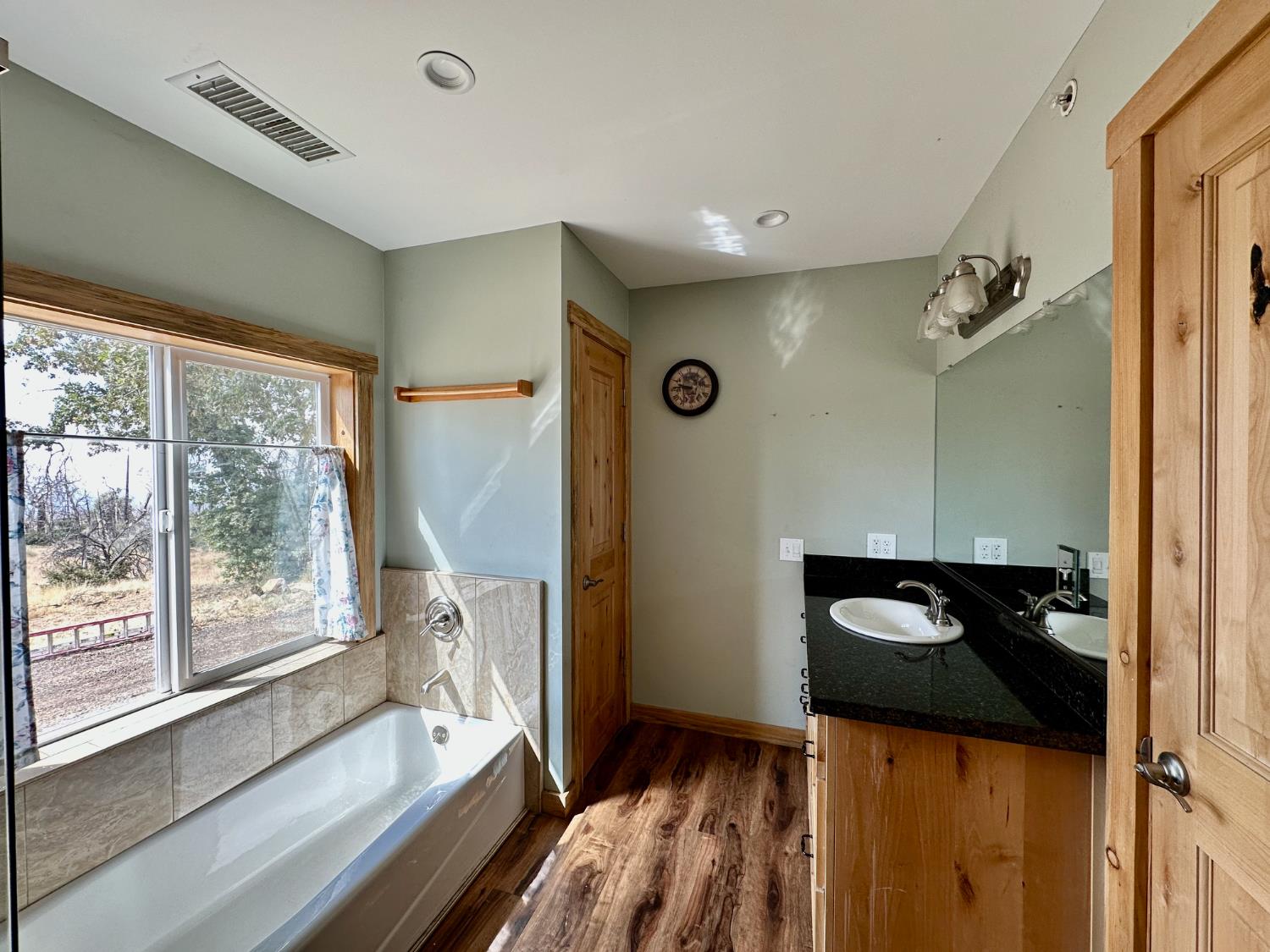 38295 Cressman Road Shaver Lake, CA 93664 - Photo 5 of 31 a view of a hallway with wooden floor and a bathroom