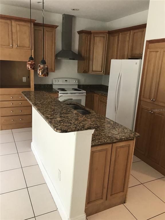1911 May Street Brandon, FL 33510 - Photo 6 of 9 a kitchen with kitchen island granite countertop a refrigerator a stove a sink and white cabinets