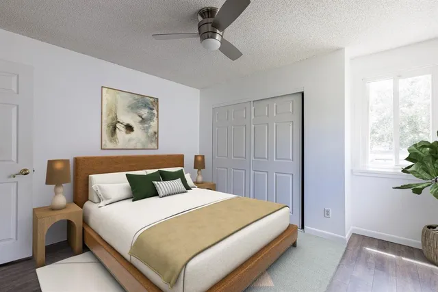 a bedroom with a bed and a painting on the wall