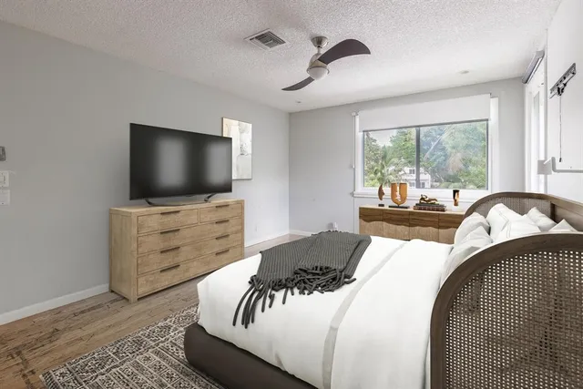 a bedroom with a bed and flat screen tv