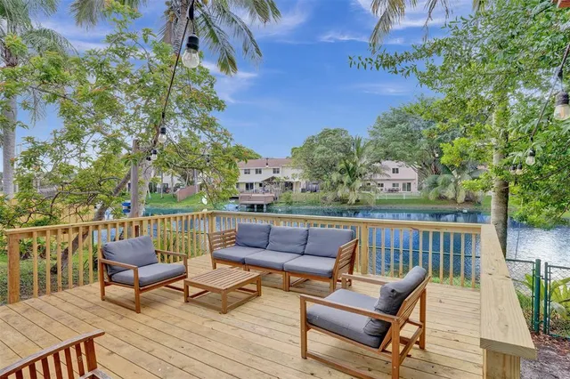 a balcony with wooden floor and outdoor seating