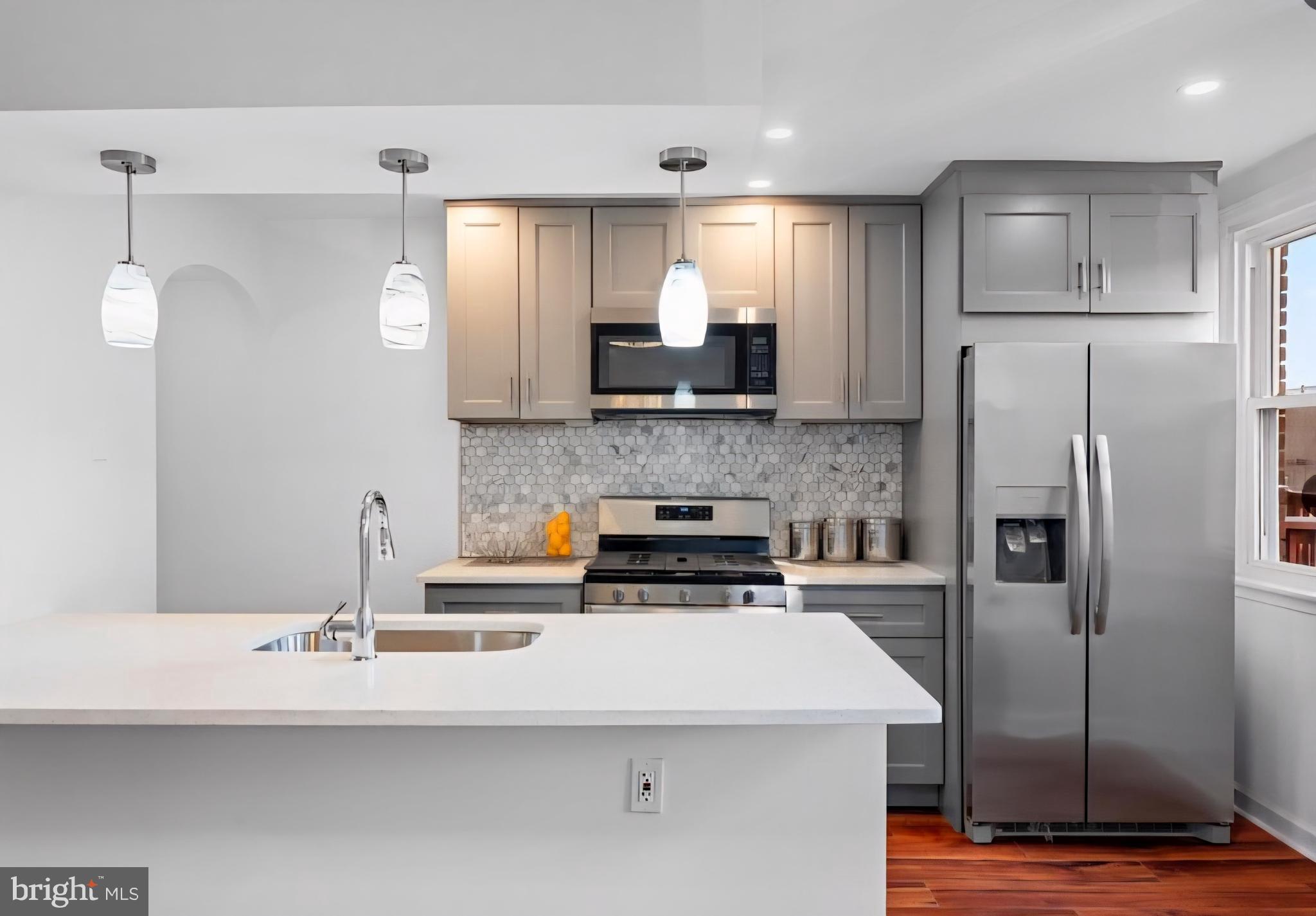 8332 Forrest Avenue Philadelphia, PA 19150 - Photo 6 of 19 a kitchen with stainless steel appliances a refrigerator sink and microwave