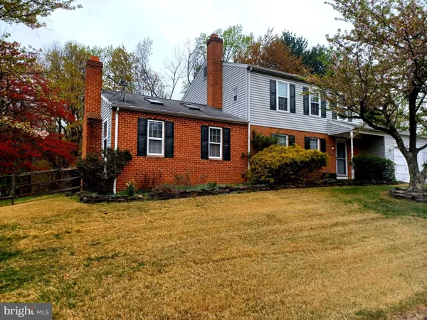 a view of a house with a yard and a large tree