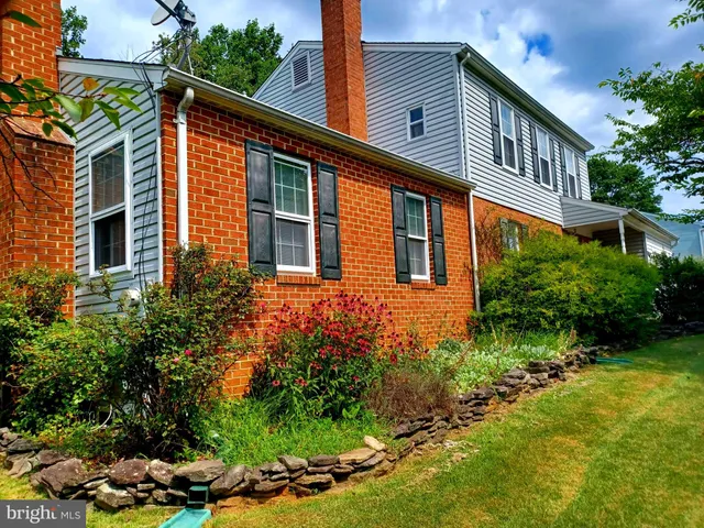 a front view of a house with a yard and fountain