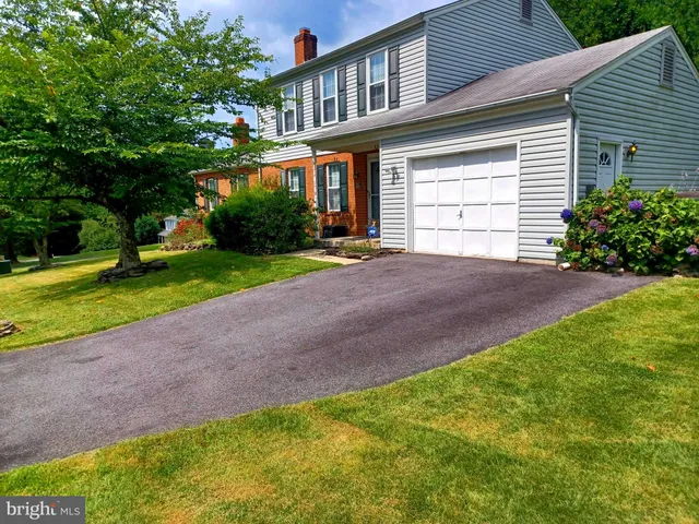 a view of a house with a big yard and large trees