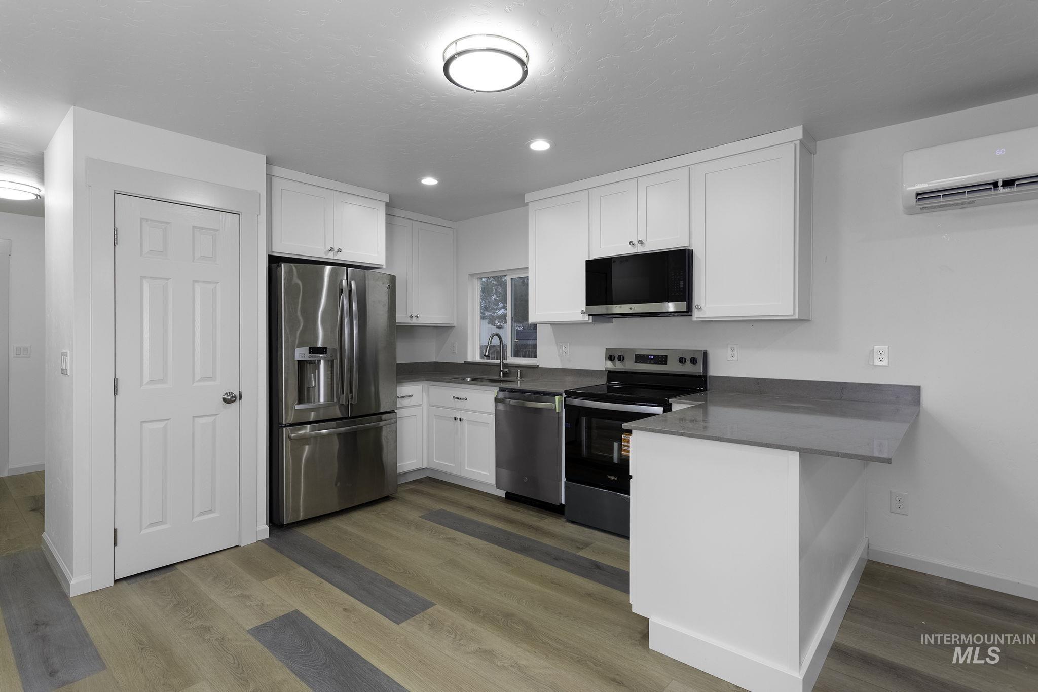 450 Greenleaf Street Boise, ID 83713 - Photo 4 of 17 Kitchen featuring stainless steel appliances, white cabinets, a peninsula, dark stone counters, and recessed lighting
