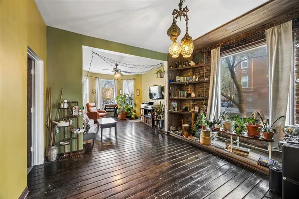 a view of a dining room and livingroom with furniture wooden floor chandelier