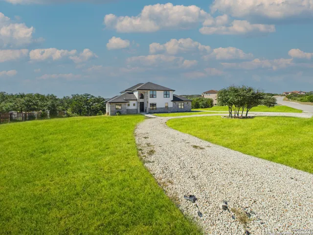 a view of a big yard with a house in the background
