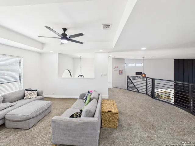a living room with furniture and a ceiling fan