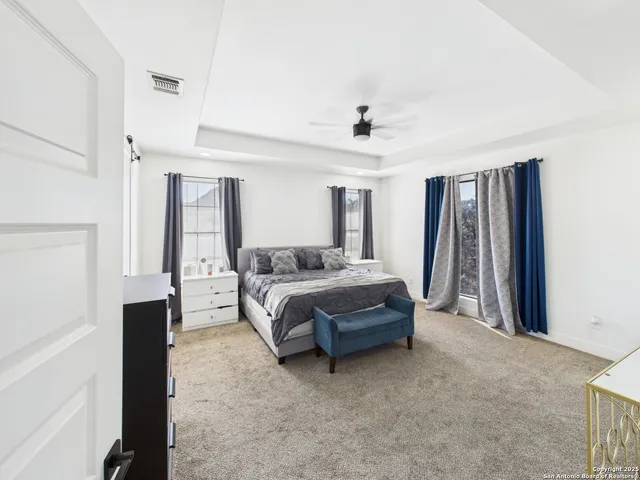 a spacious bedroom with a bed and a dresser