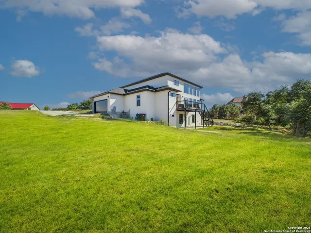 a view of a house with a big yard and large trees