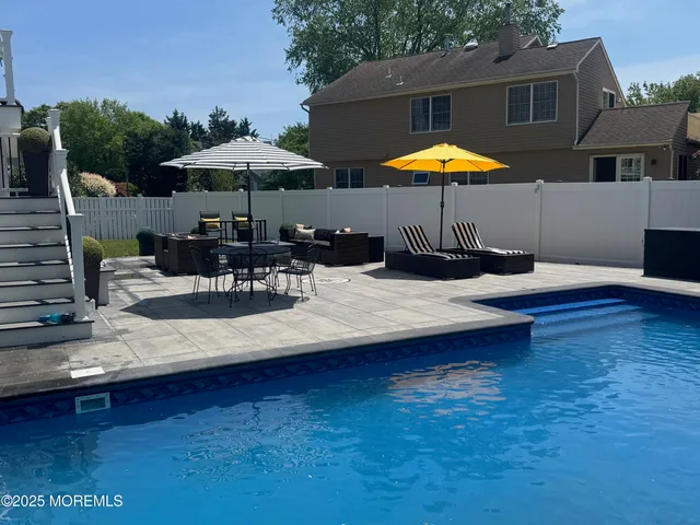 a view of a swimming pool with sitting area and furniture