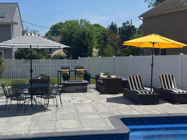 a view of a roof deck with table and chairs under an umbrella