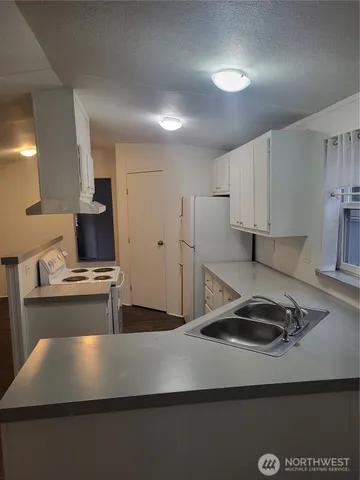 a kitchen with kitchen island a sink stainless steel appliances and cabinets