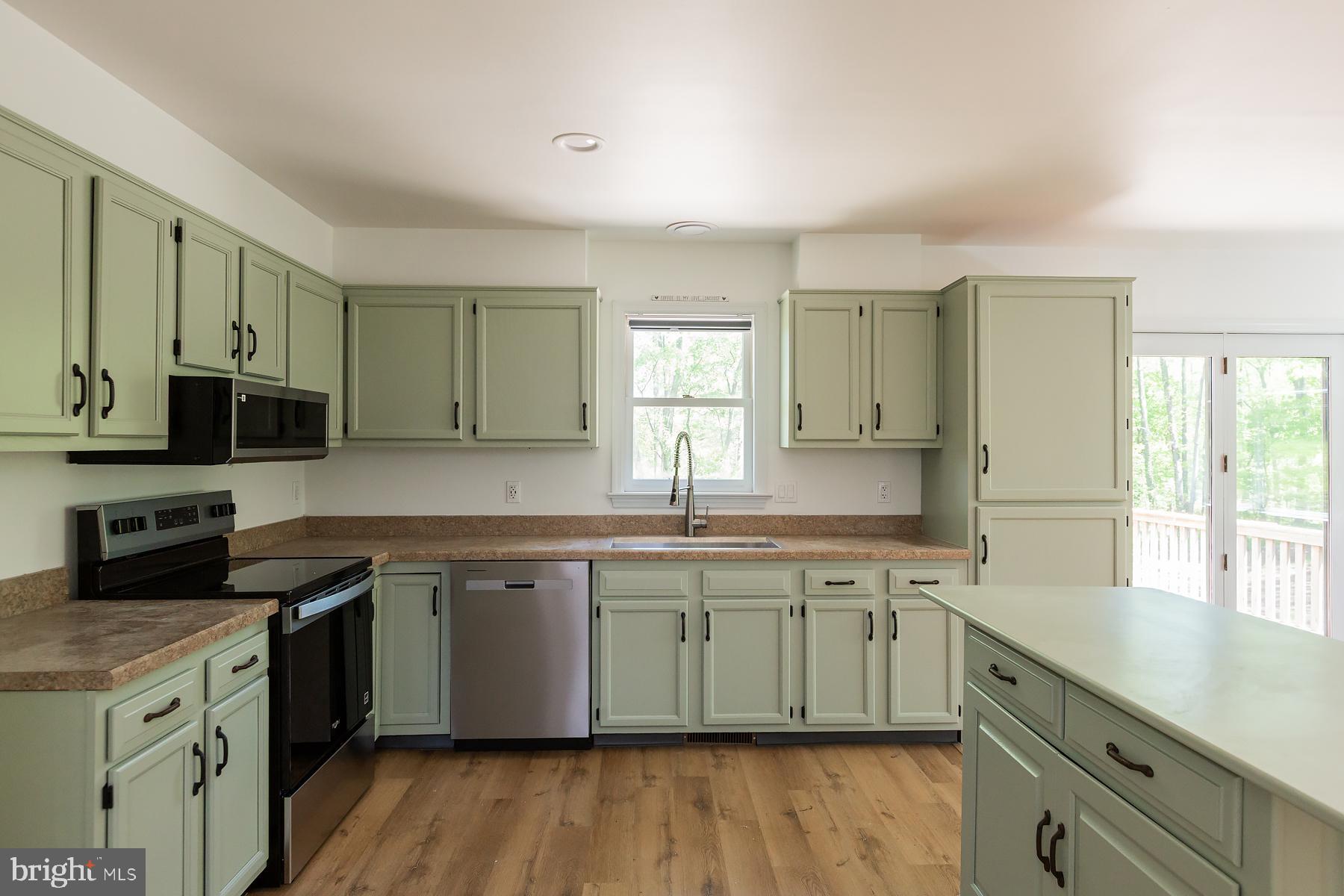 451 Red Hill Road Pequea, PA 17565 - Photo 3 of 52 a kitchen with stainless steel appliances granite countertop a sink stove cabinets and wooden floor