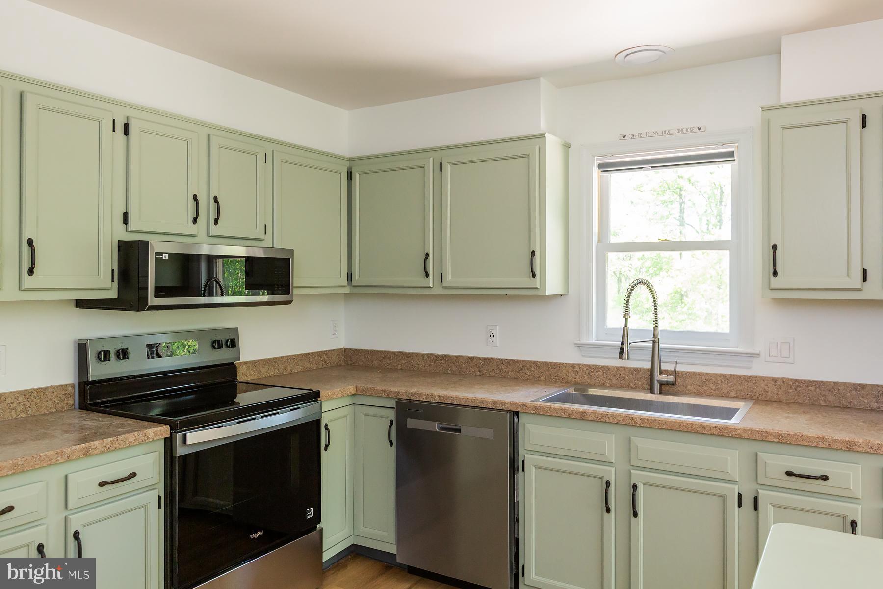 451 Red Hill Road Pequea, PA 17565 - Photo 4 of 52 a kitchen with stainless steel appliances granite countertop a sink a stove a microwave and wooden cabinets