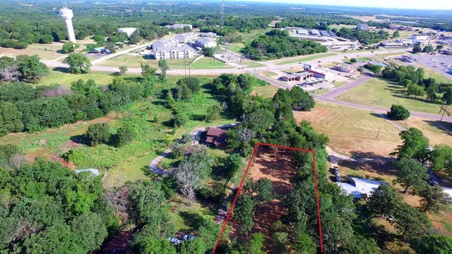 an aerial view of residential houses with outdoor space and trees