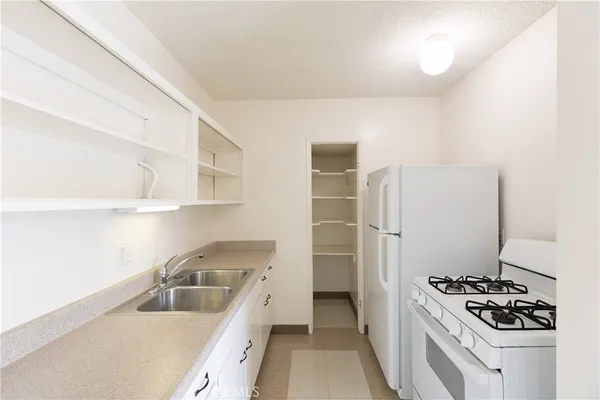a kitchen that has a sink stove and refrigerator