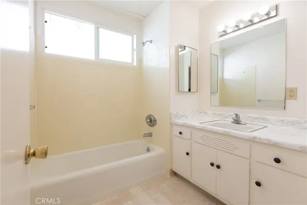 a bathroom with a granite countertop sink a mirror a and a bathtub