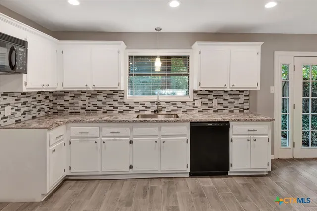 a kitchen with stainless steel appliances granite countertop a stove sink and cabinets