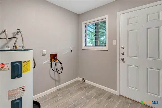 a view of an empty room and chandelier fan