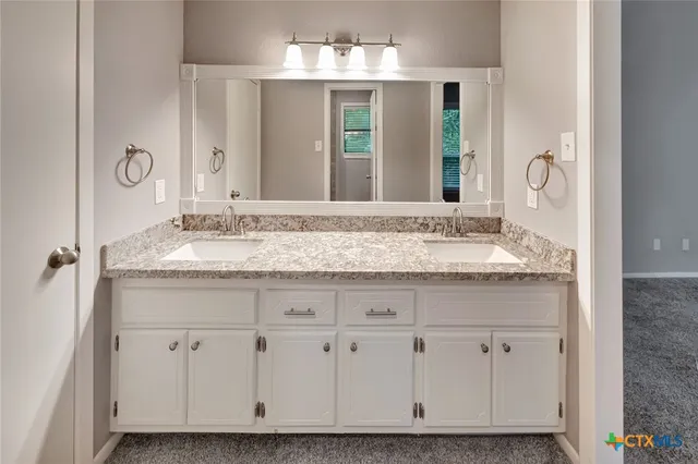 a bathroom with a granite countertop sink a mirror and a vanity