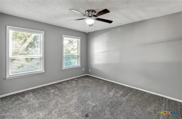 a front view of a house with a garden and trees