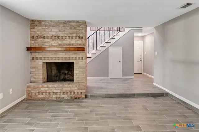 an empty room with windows and ceiling fan