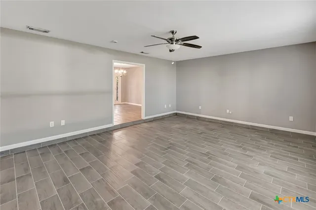 a view of a livingroom with a fireplace a chandelier and windows