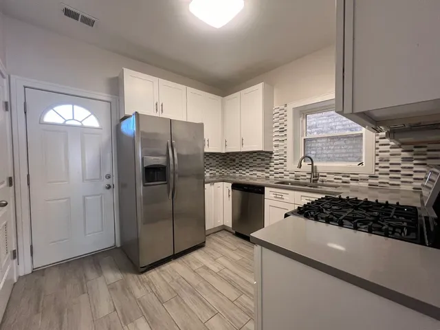 a kitchen with stainless steel appliances granite countertop a stove microwave and refrigerator