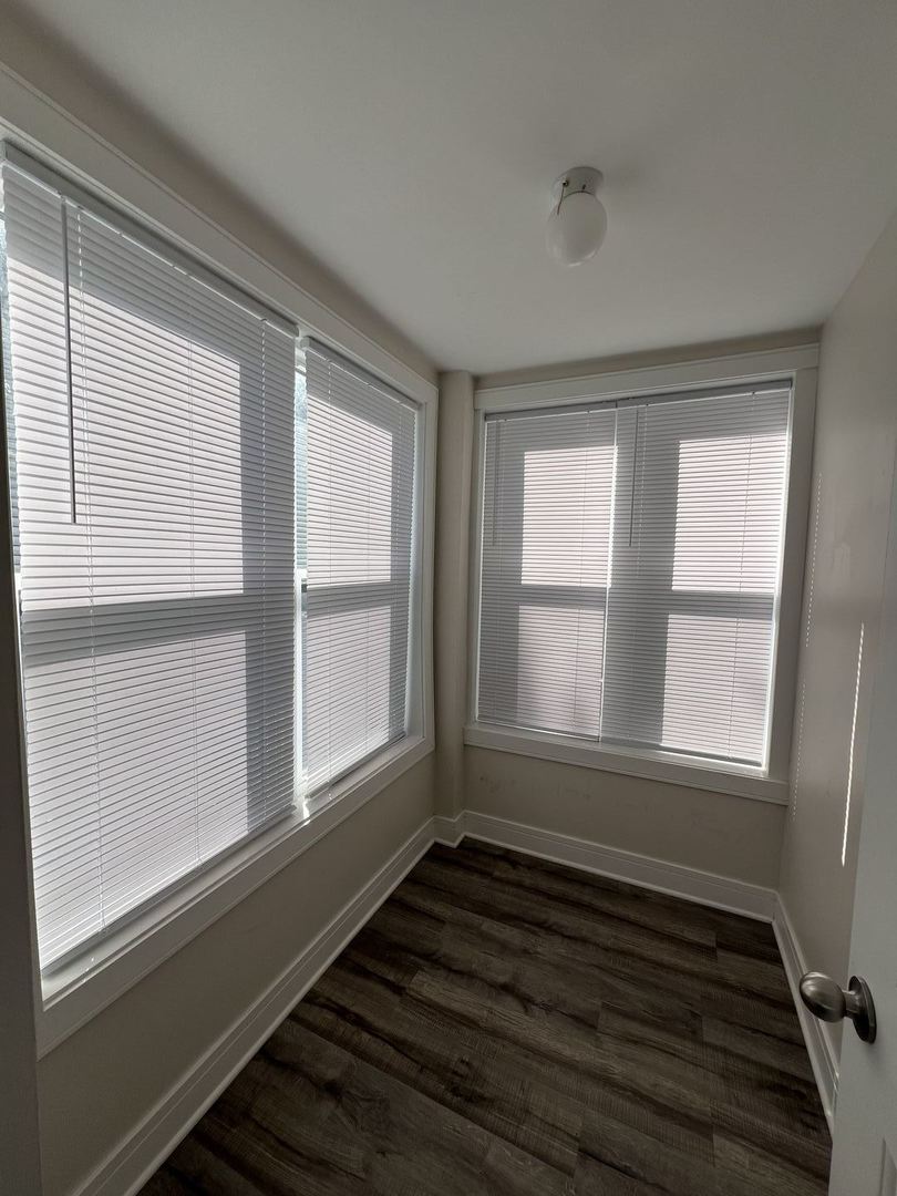 3306 West Cullom Avenue, Unit 1 Chicago, IL 60618 - Photo 5 of 16 a view of an empty room with wooden floor and a window