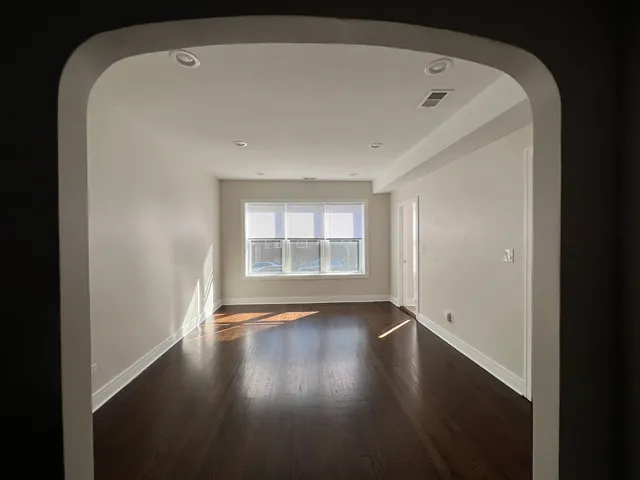 a view of wooden floor chandelier and windows in a room