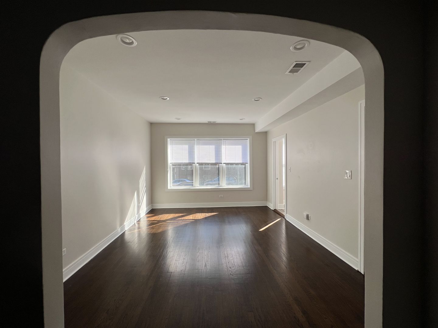 3306 West Cullom Avenue, Unit 1 Chicago, IL 60618 - Photo 6 of 16 a view of an empty room with wooden floor and a window