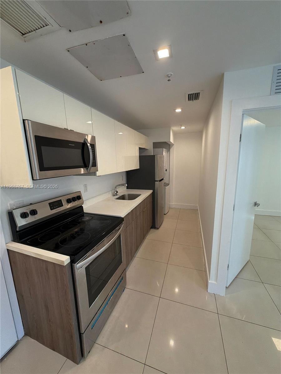 829 Southwest 18th Avenue, Unit 109 Miami, FL 33135 - Photo 2 of 10 a kitchen with stainless steel appliances granite countertop a stove and a sink