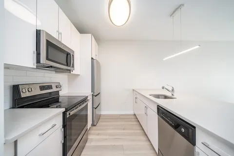 a kitchen with stainless steel appliances a stove microwave and a sink