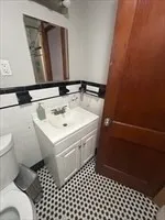 a bathroom with a sink a toilet and a mirror