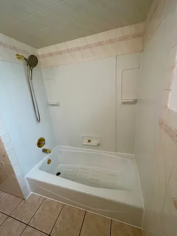 a room with furniture a flat screen tv and kitchen view