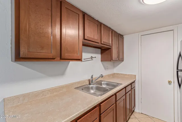 a kitchen with stainless steel appliances granite countertop a sink a stove and a refrigerator with wooden cabinets