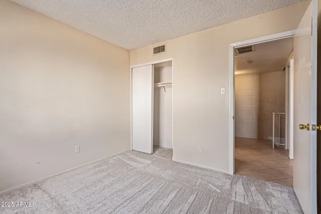 an empty room with closet and a bathroom