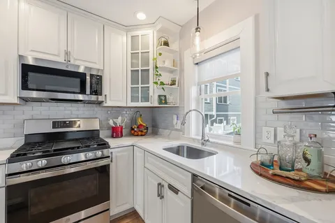 a kitchen with stainless steel appliances a stove microwave and sink