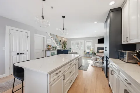 a large kitchen with kitchen island a large counter space a sink stainless steel appliances and cabinets