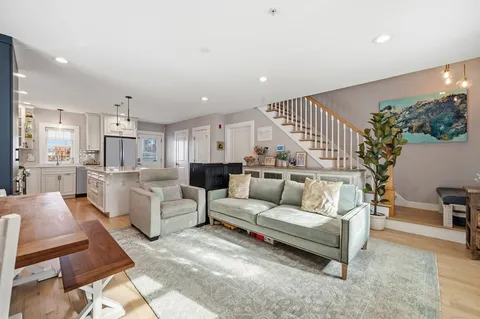 a living room with furniture and a dining table with kitchen view