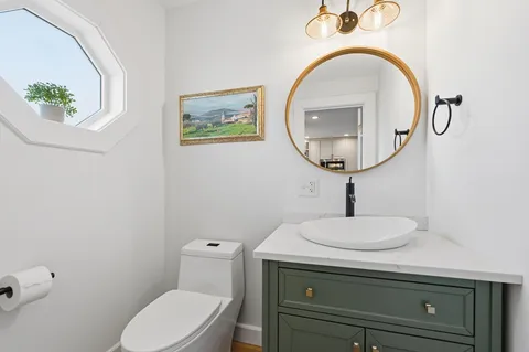 a bathroom with a toilet a sink and mirror