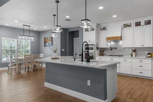 a kitchen with counter top space a sink appliances and cabinets