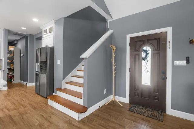 a view of a hallway with entryway wooden floor and stairs