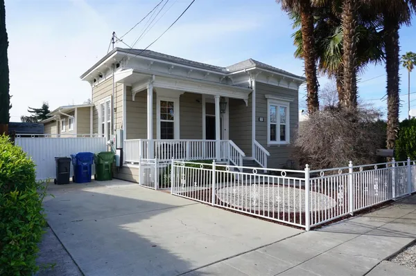 a view of a house with a small yard and wooden fence