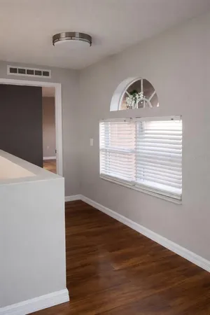 a view of a livingroom with wooden floor and a large window