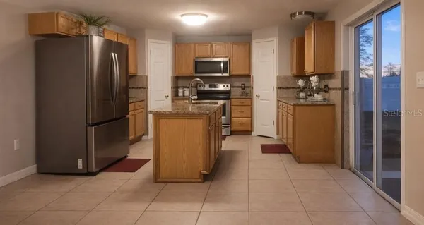 a kitchen with stainless steel appliances granite countertop a refrigerator and a stove