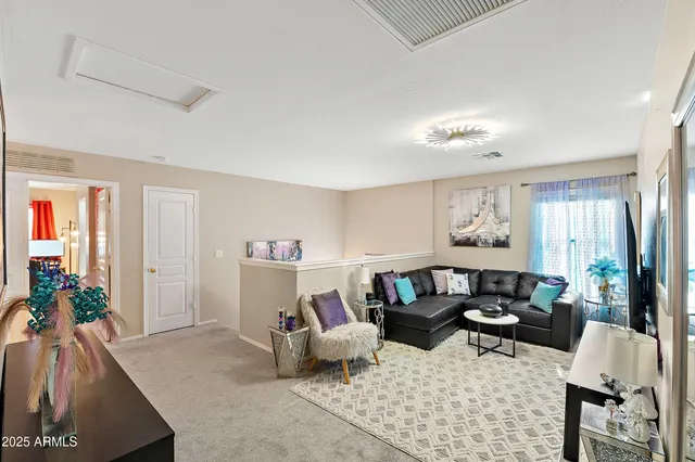 a living room with furniture flat screen tv and a large window